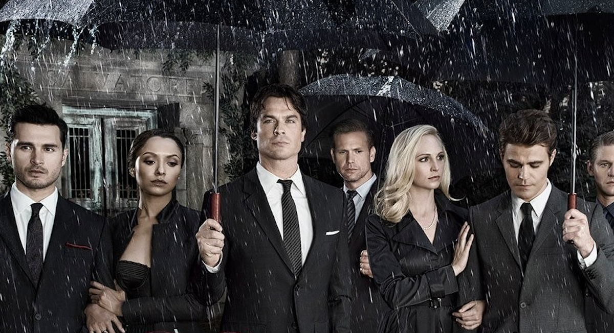 The Vampire Diaries group photo, holding umbrellas in the rain.