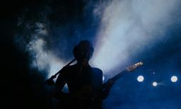 woman in black tank top playing guitar